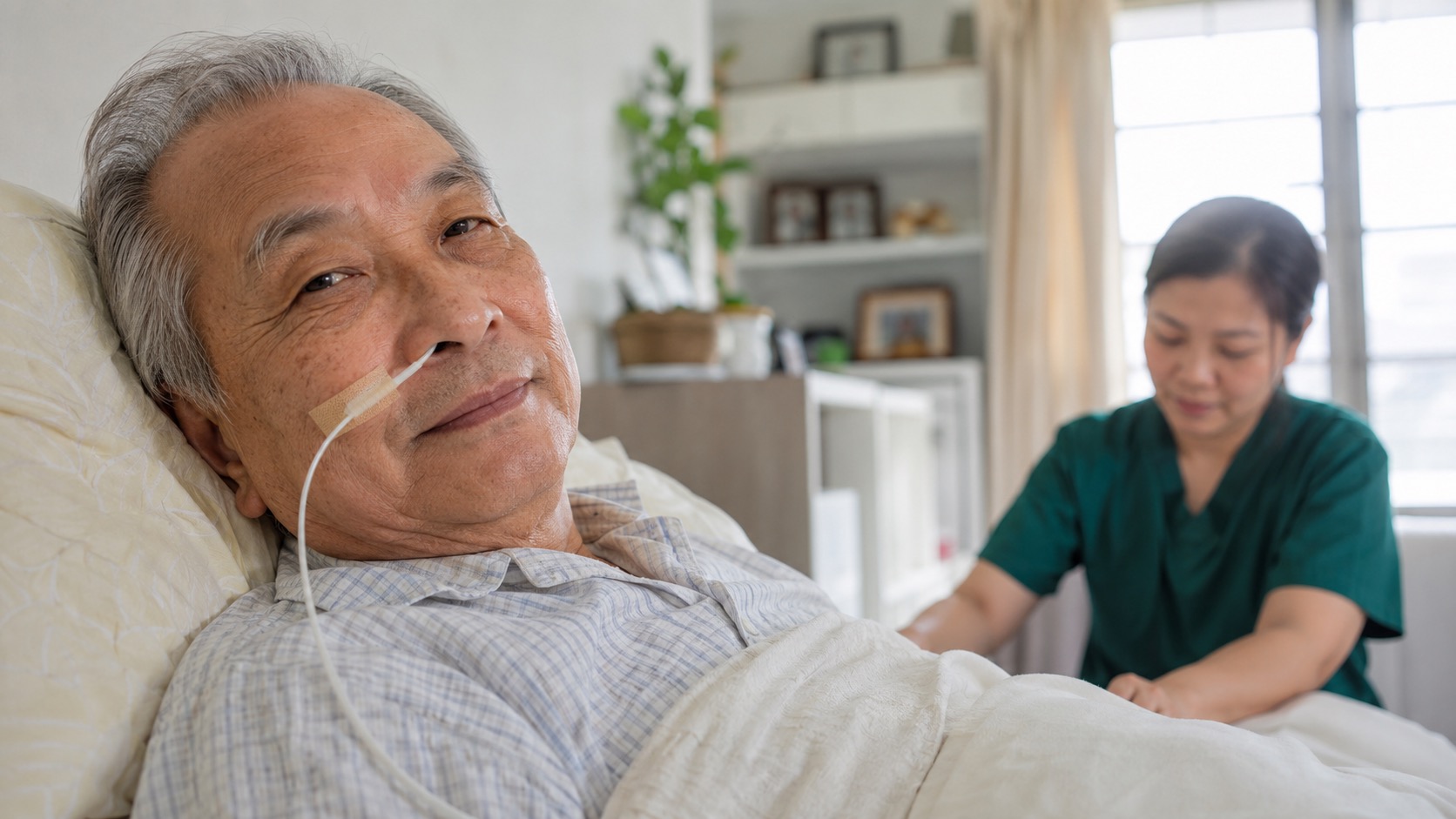 Elderly Asian patient resting comfortably at home with a nasogastric (NG) feeding tube in place, nurse in dark green scrubs nearby